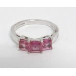 An 18ct white gold ring set with three pink sapphires.