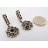 A pair of silver drop earrings set with white and red stones and with gilded decoration 1 1/2" long