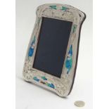 A silver photograph frame with Art Nouveau style enamel decoration.