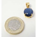 A 9ct gold pendant set with blue stone cabochon with sapphire landi like star.