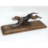 A 21st C Cold painted bronze novelty dog letter clip on wooden base/stand.