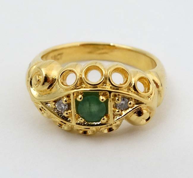 An 18ct gold ring set with central green stone flanked by two diamonds CONDITION: