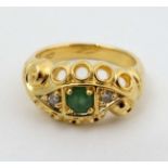 An 18ct gold ring set with central green stone flanked by two diamonds CONDITION: