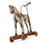 *Toy horse. A push along toy horse, early 20th century, carved wood and gesso dapple grey horse,