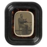 *Ambrotypes. A large half-plate ambrotype of a hatmaker, circa 1855, full length, seated, period