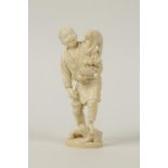 A JAPANESE ONE PIECE CARVED ELEPHANT IVORY FIGURAL OKIMONO "The Monkey Trainer", standing with his