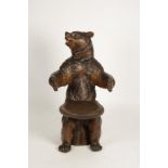 A BLACK FOREST STYLE CHILD'S SEAT in the form of a bear with arms outstretched, naturalistically