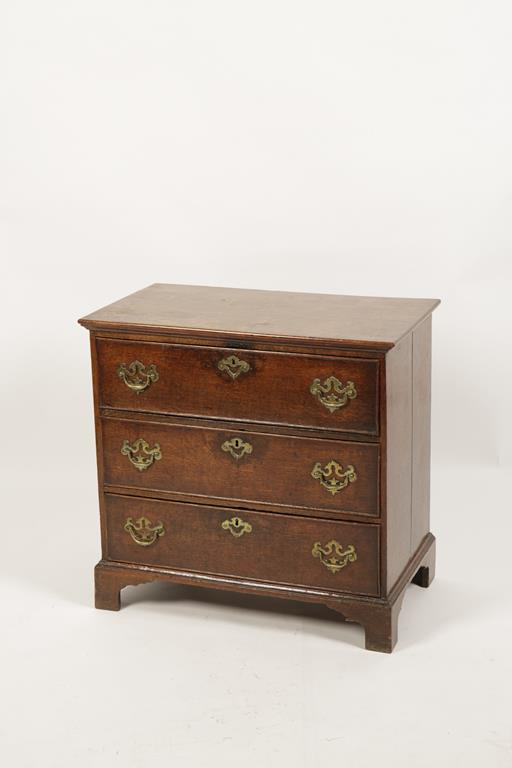 A GEORGE III OAK CHEST OF DRAWERS, the rectangular top above three short drawers with brass