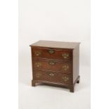 A GEORGE III OAK CHEST OF DRAWERS, the rectangular top above three short drawers with brass