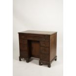 A MAHOGANY KNEEHOLE WRITING DESK, the rectangular top with a moulded border above a baize-lined