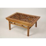 A CHINESE HARDWOOD OCCASIONAL TABLE, the rectangular top with central fretwork panel with carved