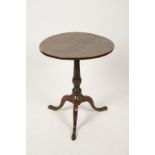 A GEORGE III MAHOGANY CIRCULAR TIP-TOP OCCASIONAL TABLE, the one piece top on a vase-turned column