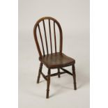 A MINIATURE WINDSOR CHAIR with hooped back, solid seat and turned legs and stretchers, 19th/20th