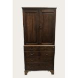 AN OAK PRESS OR HOUSEKEEPERS CUPBOARD, the top with two panelled doors enclosing a shelved interior,