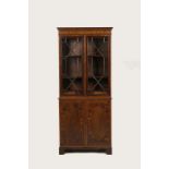 AN EDWARDIAN MAHOGANY SHERATON STYLE CABINET, the upper section with a dentil-moulded cornice