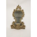 A CARVED AND PAINTED ROCOCO STYLE CARTOUCHE MIRROR, the waisted plate in an elaborate scrolling