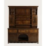 A GEORGE III OAK DRESSER, the raised back with a moulded cornice above an openwork frieze and an