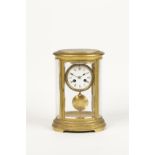 A BRASS "FOUR GLASS" OVAL MANTEL CLOCK