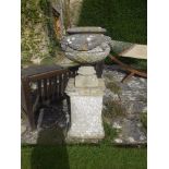 A PAIR OF RECONSTITUTED STONE GARDEN URNS AND PEDESTALS of circular form with masked faces and