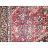 A NORTH WEST PERSIAN TYPE CARPET worked with geometric and foliate patterns against a red ground