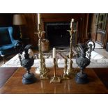 A PAIR OF BRASS CANDLESTICKS with tapering sconces above narrow drip pans, on slender columns and