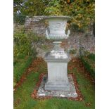 A PAIR OF RECONSTITUTED STONE GARDEN URNS AND PEDESTALS, the urns of circular flared form with