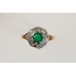 AN EMERALD AND DIAMOND CLUSTER RING