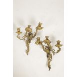 A PAIR OF ROCOCO STYLE GILT METAL THREE BRANCH WALL LIGHTS with stagge