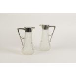 A PAIR OF CONTINENTAL SILVER MOUNTED CUT-GLASS CLARET JUGS