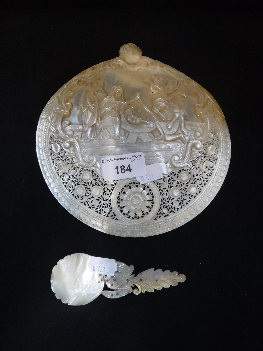 A DECORATIVE PIERCED MOTHER-OF-PEARL BAPTISMALSHELL decorated with a scene of the Nativity and a