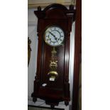 A WALNUT CASED WALL CLOCK by Highlands, with a brass pendulum