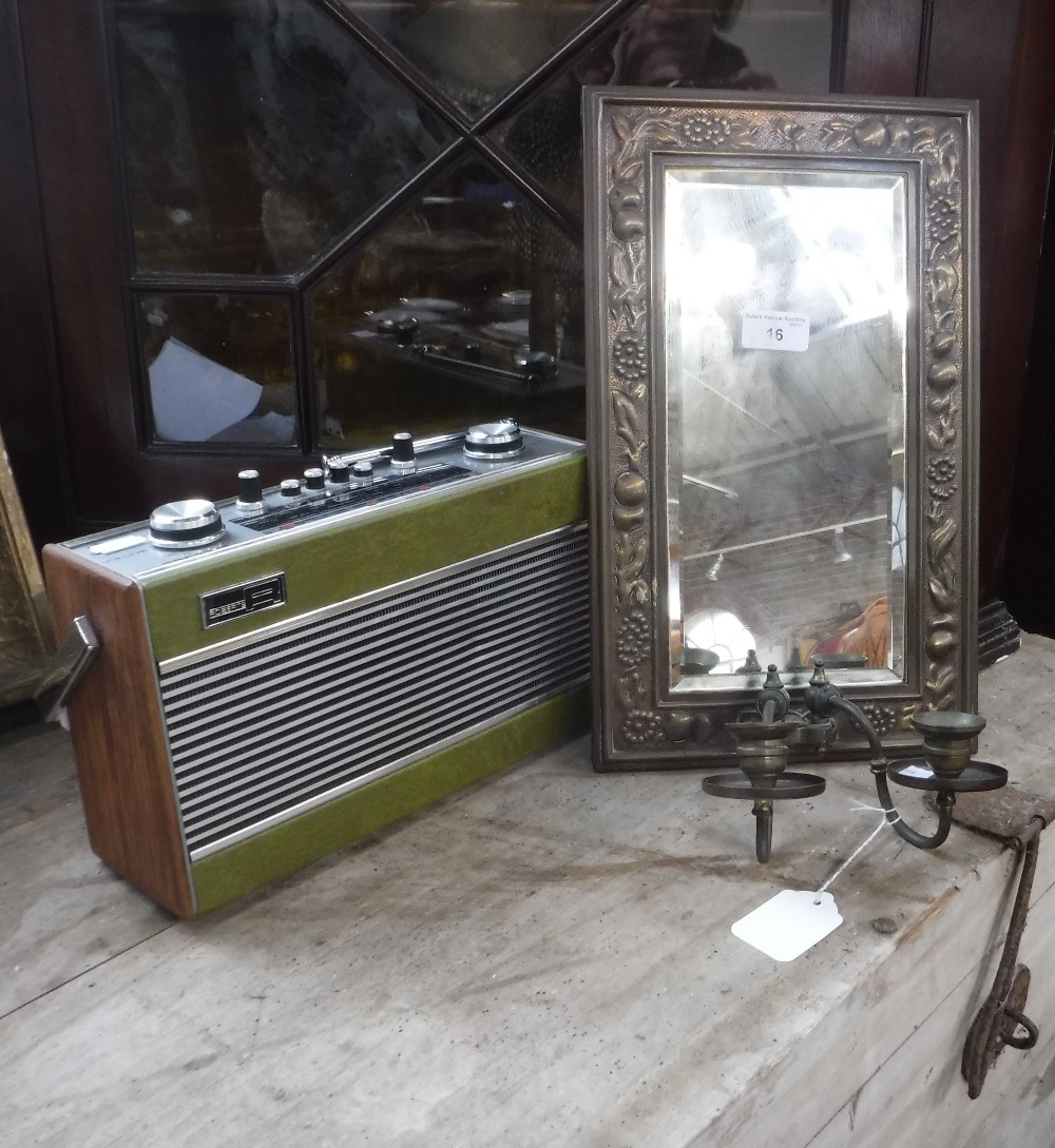 A BRASS FRAMED WALL MIRROR with candle sconces and a vintage 'Roberts' radio