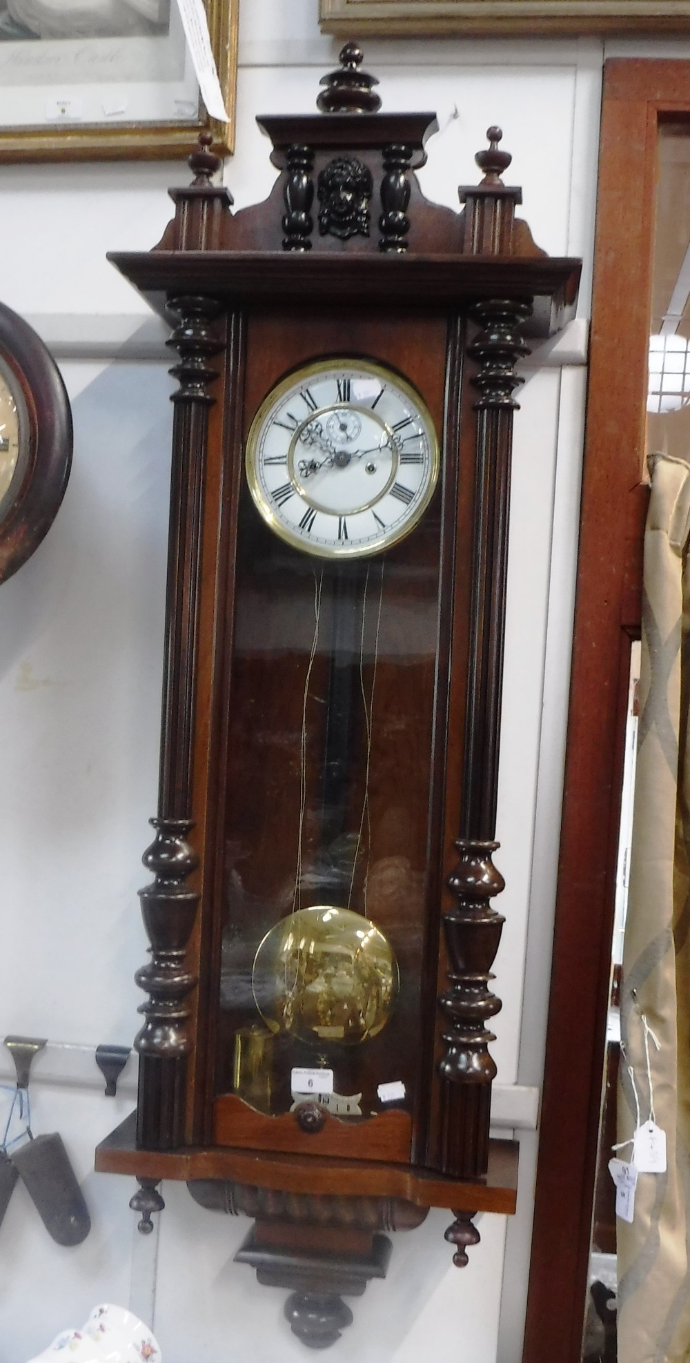 A VIENNA WALL CLOCK, in a glazed stained wooden case, with two train movement 46" high