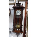 A VIENNA WALL CLOCK, in a glazed stained wooden case, with two train movement 46" high