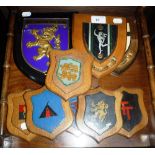 A COLLECTION OF MILITARY SHIELDS and armorial crests, mainly hand-painted mounted on oak