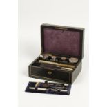 A 19TH CENTURY FRENCH EBONISED AND BRASS INLAID WORKBOX containing a quantity of manicure tools