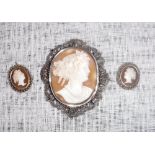 A WHITE METAL CAMEO BROOCH and a pair of similar earrings