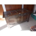 A 17TH CENTURY OAK PANELLED COFFER with carved arcaded decoration to the top rail 43" wide