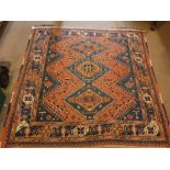 A PERSIAN RUG with red/blue ground with geometric design all over, approx. 65" x 69"