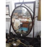 A GEORGE III DRESSING TABLE MIRROR, the oval plate within a scrolling frame