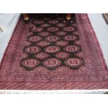 A MODERN FINE WEAVE BOKHARA TYPE RUG of traditional design on a dark ground, approx. 73" x 107"