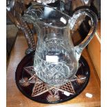 A LARGE CUT-GLASS JUG and a red overlaid cut-glass tray