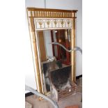 A REGENCY STYLE PIER GLASS with reeded flanking columns, a frieze of palm leaves with acanthus