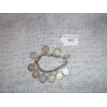 A SILVER CHAIN LINK BRACELET with attached coins