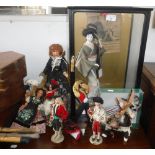 A JAPANESE STUDY OF A GEISHA in a glazed case and similar dolls from around the world