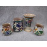 THREE POOLE POTTERY VASES with bright floral decoration and a similar blue bird jug