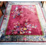 A LARGE RED GROUND CHINESE RUG, decorated with vases of flowers within floral borders, 108" x 140"