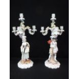 A PAIR OF 'MEISSEN' PORCELAIN THREE BRANCH CANDELABRA, modelled as figures against floral