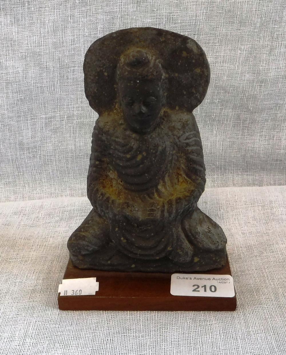 A CARVED STONE FIGURE OF A SEATED DEITY