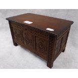 A MINIATURE CARVED OAK PANELLED COFFER